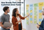 A product team at a whiteboard grouping customer feedback notes into themes, with one theme marked as shipped.