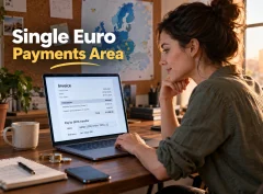 A studio owner reviews an invoice with SEPA transfer details and a euro IBAN on a laptop.